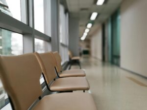 Row of empty chairs in a hospital corridor, soft lighting and modern interior design.